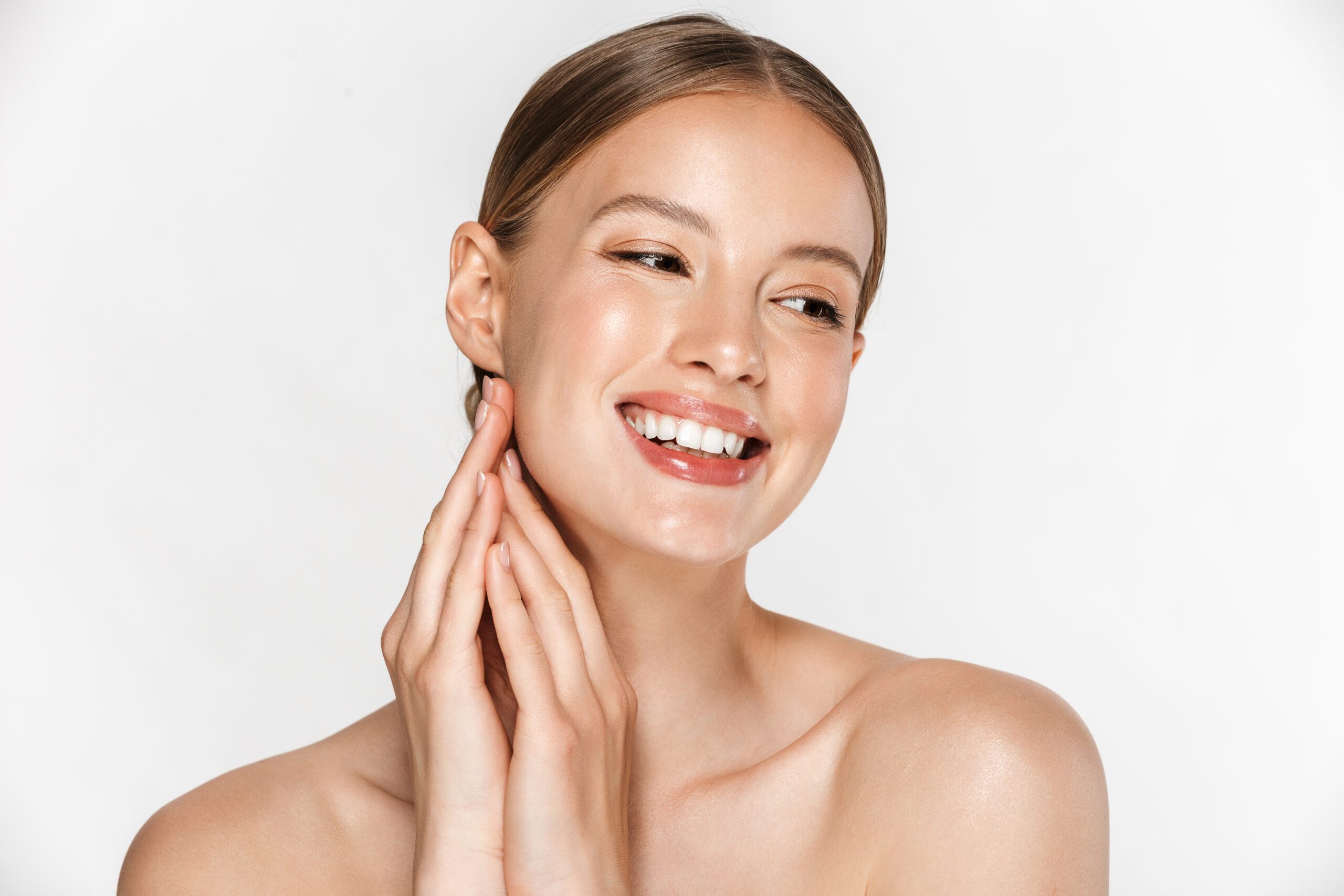 Beautiful young woman with healthy glowy skin posing isolated over white wall background.